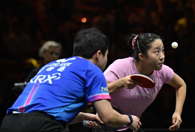 South Korea’s Shin Yu-bin (R) serves next to Lim Jong-hoon to Japan’s Sora Matsushima and Miwa Harimoto during their mixed doubles semifinal match at the China WTT Smash table tennis tournament in Beijing on October 8, 2026. (Photo by Adek BERRY / AFP)