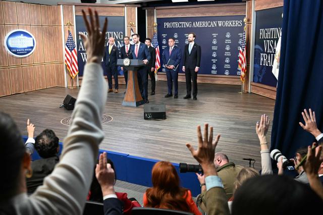 Reporters raise their hands to ask questions to US Vice President JD Vance as he speaks alongside (L-R) White House Deputy Chief of Staff and Homeland Security Advisor Stephen Miller, US Attorney General Todd Blanche, US Labor Secretary Keith Sonderling, Inspector General of the US Department of Labor Anthony D'Esposito and Federal Trade Commission (FTC) Chair Andrew Ferguson during a press conference to provide an update in the federal investigation and crackdown regarding fraud and abuse of the H-1B visa program in Washington, DC, on October 8, 2026. (Photo by Alex WROBLEWSKI / AFP)