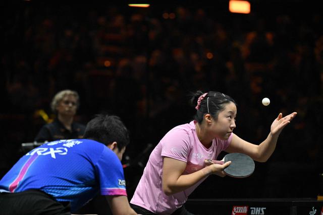 South Korea’s Shin Yu-bin (R) serves next to Lim Jong-hoon to Japan’s Sora Matsushima and Miwa Harimoto during their mixed doubles semifinal match at the China WTT Smash table tennis tournament in Beijing on October 8, 2026. (Photo by Adek BERRY / AFP)