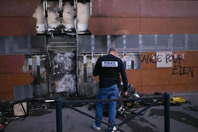 A judicial police officer inspects the facade of the Capucins Market after it was set on fire by protesters during a high-school student demonstration in Bordeaux on October 8, 2026, as part of a nationwide movement over learning conditions. Since late September, pupils have barred the entrances to hundreds of schools, complaining of teacher absences, overloaded timetables, dilapidated classrooms and buildings ill-adapted to rising temperatures, among other grievances. (Photo by Christophe ARCHAMBAULT / AFP)