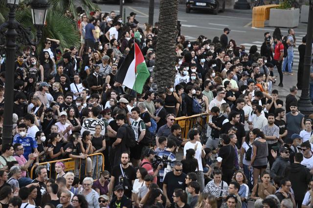 People at a housing rights activists' camp gather ahead of a demonstration called by far-right groups seeking the camp's eviction at City Hall Square in Valencia, eastern Spain, on October 8, 2026. (Photo by Jose JORDAN / AFP)