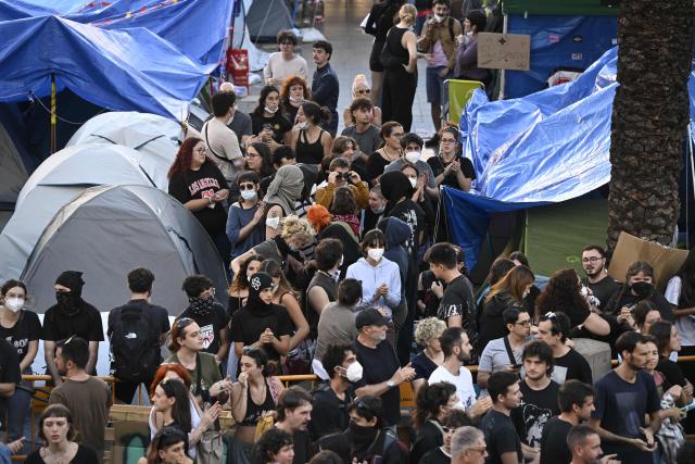 People at a housing rights activists' camp gather ahead of a demonstration called by far-right groups seeking the camp's eviction at City Hall Square in Valencia, eastern Spain, on October 8, 2026. (Photo by Jose JORDAN / AFP)