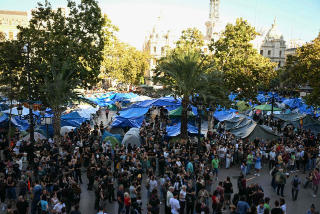 People at a housing rights activists' camp gather ahead of a demonstration called by far-right groups seeking the camp's eviction at City Hall Square in Valencia, eastern Spain, on October 8, 2026. (Photo by JOSE JORDAN / AFP)
