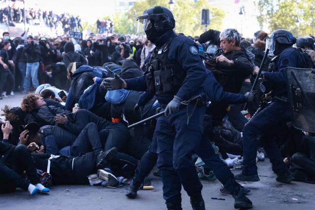 French police officers clash with protesters during a demonstration of high-school students at Place de la Bastille, in Paris, on October 8, 2026, as part of a nationwide protest movement over learning conditions. Since late September, pupils have barred the entrances to hundreds of schools, complaining of teacher absences, overloaded timetables, dilapidated classrooms and buildings ill-adapted to rising temperatures, among other grievances. (Photo by Kenzo TRIBOUILLARD / AFP)