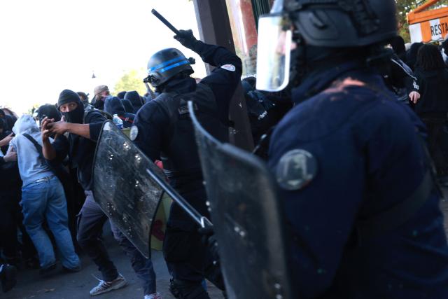 French police officers clash with protesters during a demonstration of high-school students at Place de la Bastille, in Paris, on October 8, 2026, as part of a nationwide protest movement over learning conditions. Since late September, pupils have barred the entrances to hundreds of schools, complaining of teacher absences, overloaded timetables, dilapidated classrooms and buildings ill-adapted to rising temperatures, among other grievances. (Photo by Kenzo TRIBOUILLARD / AFP)