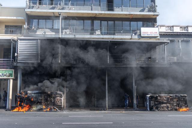 TOPSHOT - Cars are set alight after clashes erupt between protesters and foreign nationals in Durban on October 8, 2026. Several vehicles were set alight during the confrontation amid tensions over undocumented immigration and foreign nationals. South African protesters and foreign nationals clashed Thursday, police and an AFP reporter said, as tensions over migration were reignited by a court order that government must restart processing asylum applications.
Violence erupted in Soweto, in Johannesburg, and the east coast port city of Durban, with several cars torched and foreign-run businesses forced to close.
It followed protests called by anti-illegal migration movements that were behind waves of demonstrations earlier this year that led tens of thousands of nationals of other African countries to flee the country. (Photo by RAJESH JANTILAL / AFP)
