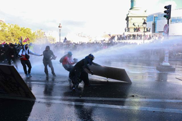TOPSHOT - Protesters clash with riot police during a demonstration of high-school students at Place de la Bastille, in Paris, on October 8, 2026, as part of a nationwide protest movement over learning conditions. Since late September, pupils have barred the entrances to hundreds of schools, complaining of teacher absences, overloaded timetables, dilapidated classrooms and buildings ill-adapted to rising temperatures, among other grievances. (Photo by Kenzo TRIBOUILLARD / AFP)