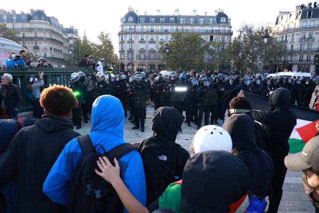 French police officers of the Repression of Violent Action Motorised Brigade (Brav-M or Brigade de repression de l'action violente motorisee) hold strobe-capable shields during a demonstration of high-school students at Place de la Bastille, in Paris, on October 8, 2026, as part of a nationwide protest movement over learning conditions. Since late September, pupils have barred the entrances to hundreds of schools, complaining of teacher absences, overloaded timetables, dilapidated classrooms and buildings ill-adapted to rising temperatures, among other grievances. (Photo by Kenzo TRIBOUILLARD / AFP)