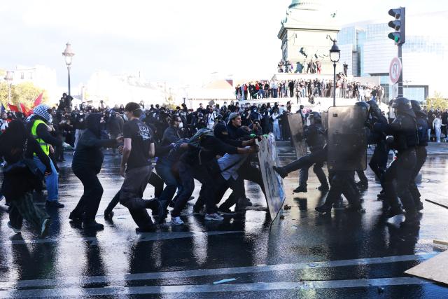 French police officers clash with protesters during a demonstration of high-school students at Place de la Bastille, in Paris, on October 8, 2026, as part of a nationwide protest movement over learning conditions. Since late September, pupils have barred the entrances to hundreds of schools, complaining of teacher absences, overloaded timetables, dilapidated classrooms and buildings ill-adapted to rising temperatures, among other grievances. (Photo by Kenzo TRIBOUILLARD / AFP)