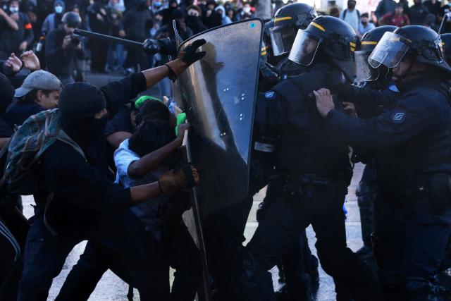 French Republican Security Corps (CRS - Compagnies Republicaines de Securite) police officers clash with protesters during a demonstration of high-school students at Place de la Bastille, in Paris, on October 8, 2026, as part of a nationwide protest movement over learning conditions. Since late September, pupils have barred the entrances to hundreds of schools, complaining of teacher absences, overloaded timetables, dilapidated classrooms and buildings ill-adapted to rising temperatures, among other grievances. (Photo by Kenzo TRIBOUILLARD / AFP)