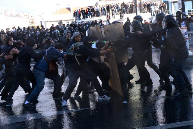 French Republican Security Corps (CRS - Compagnies Republicaines de Securite) police officers clash with protesters during a demonstration of high-school students at Place de la Bastille, in Paris, on October 8, 2026, as part of a nationwide protest movement over learning conditions. Since late September, pupils have barred the entrances to hundreds of schools, complaining of teacher absences, overloaded timetables, dilapidated classrooms and buildings ill-adapted to rising temperatures, among other grievances. (Photo by Kenzo TRIBOUILLARD / AFP)
