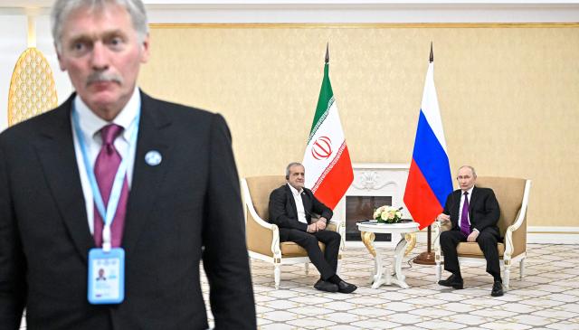 In this pool photograph distributed by the Russian state agency Sputnik, Russia's President Vladimir Putin and Iranian President Masoud Pezeshkian hold a meeting in Turkmenbashi on October 8, 2026. (Photo by Sergei BOBYLYOV / POOL / AFP)