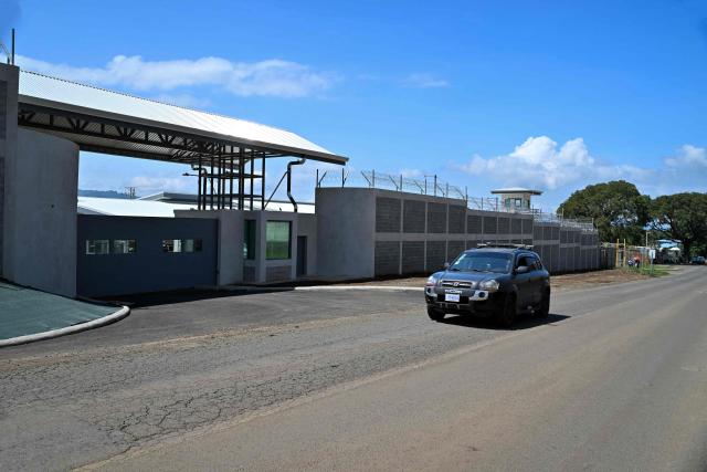 A vehicle drives past the High-Security Center for Organized Crime Containment (CACCO) in Alajuela, Costa Rica, on October 8, 2026. The mega-prison, modeled after El Salvador's maximum-security CECOT, is scheduled to be inaugurated on October 14, 2026, as Costa Rica seeks to strengthen its response to organized crime. (Photo by Ezequiel BECERRA / AFP)