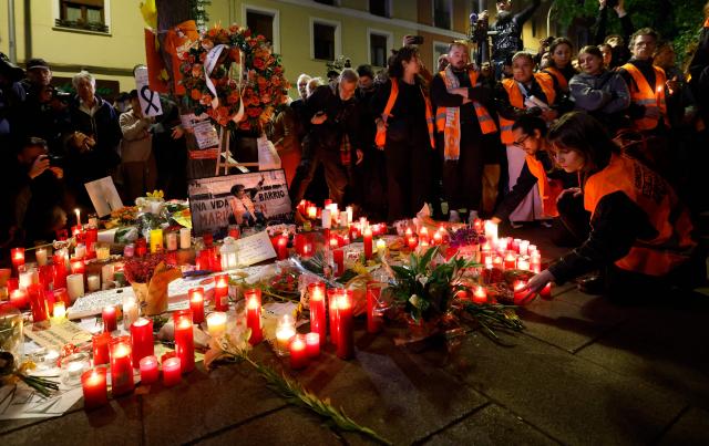Protesters gather to pay tribute to Maricarmen Abascal in front of her apartment, the 87-year-old pensioner whose eviction triggered nationwide protests over Spain's chronic housing crisis and a political debate that culminated in early elections, during a demonstration in Madrid on October 8, 2026. Abascal became a symbol of Spain's housing market on September 23 when she was evicted from her life-long Madrid home on a stretcher after the real estate firm that owned the apartment drastically hiked the rent. (Photo by Oscar DEL POZO / AFP)