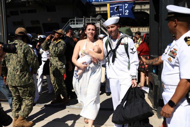Families reunited with sailors as they disembark the US Navy aircraft carrier USS Abraham Lincoln (CVN-72) which arrived at Naval Air Station North Island in San Diego, California, on October 8, 2026. The Nimitz-class warship returned from a lengthy, difficult Iran war deployment in which multiple service members in the carrier strike group attempted suicide. The massive nuclear-powered warship left California in November 2025 for duty in the South China Sea and was rerouted to the Middle East before US-Israeli attacks on Iran that began in late February, staying at sea until a Thailand port call in early September. (Photo by David Swanson / AFP)