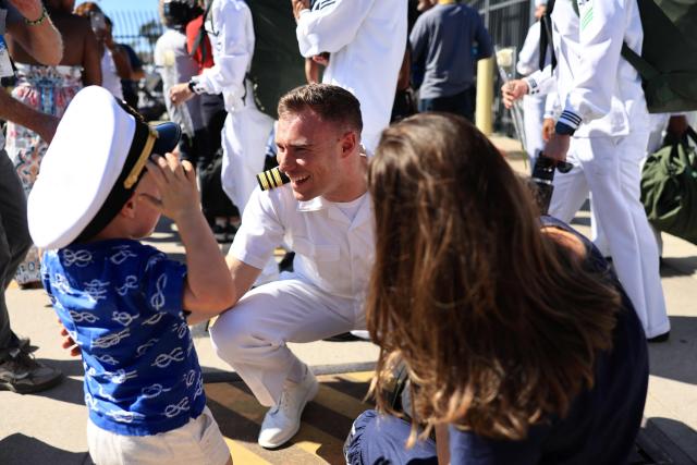 Families reunite with sailors as they disembark the US Navy aircraft carrier USS Abraham Lincoln (CVN-72) which arrived at Naval Air Station North Island in San Diego, California, on October 8, 2026. The Nimitz-class warship returned from a lengthy, difficult Iran war deployment in which multiple service members in the carrier strike group attempted suicide. The massive nuclear-powered warship left California in November 2025 for duty in the South China Sea and was rerouted to the Middle East before US-Israeli attacks on Iran that began in late February, staying at sea until a Thailand port call in early September. (Photo by David Swanson / AFP)
