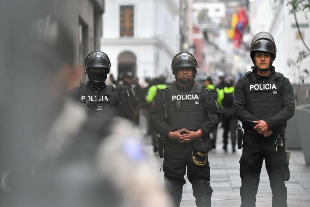 Police officers stand guard during a march organized by Ecuadorean unions and social movements against the government of President Daniel Noboa in Quito on October 8, 2026. (Photo by Rodrigo BUENDIA / AFP)