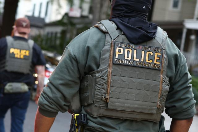 Federal agents walk near the scene where a man was shot by an Immigration and Customs Enforcement (ICE) officer during an operation in the Bronx borough of New York on October 8, 2026, according to local media and police. (Photo by CHARLY TRIBALLEAU / AFP)