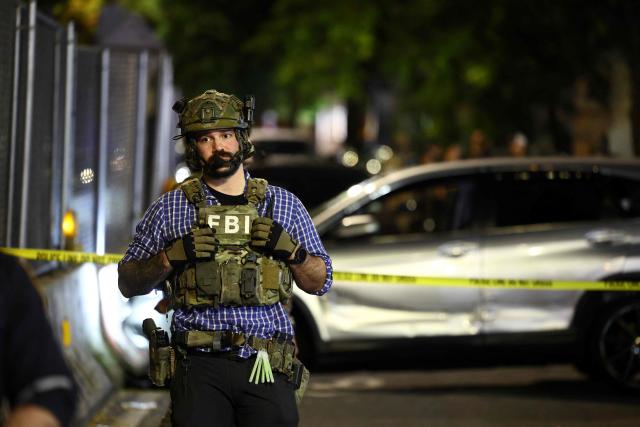 Federal agents stand close to the scene where a man was shot by an Immigration and Customs Enforcement (ICE) officer during an operation in the Bronx borough of New York on October 8, 2026, according to local media and police. (Photo by CHARLY TRIBALLEAU / AFP)