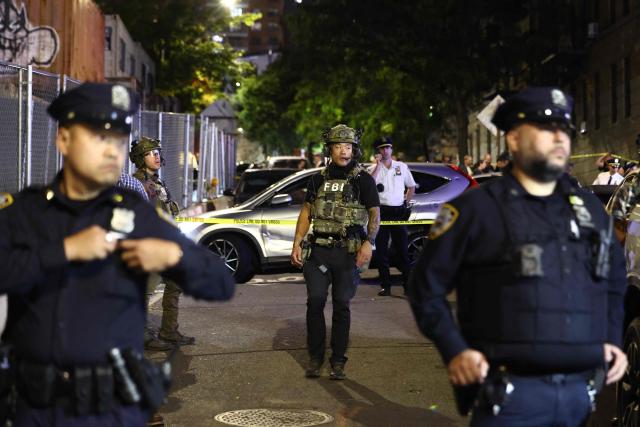 Federal and local law enforcement officers close to the scene where a man was shot by an Immigration and Customs Enforcement (ICE) officer during an operation in the Bronx borough of New York on October 8, 2026, according to local media and police. (Photo by CHARLY TRIBALLEAU / AFP)