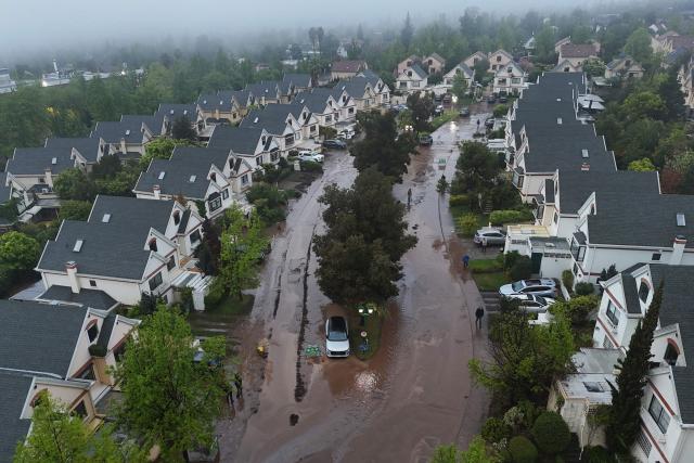 This aerial view shows a street covered in mud and debris following a mudslide in the Las Condes district of Santiago on October 8, 2026. (Photo by Rodrigo ARANGUA / AFP)