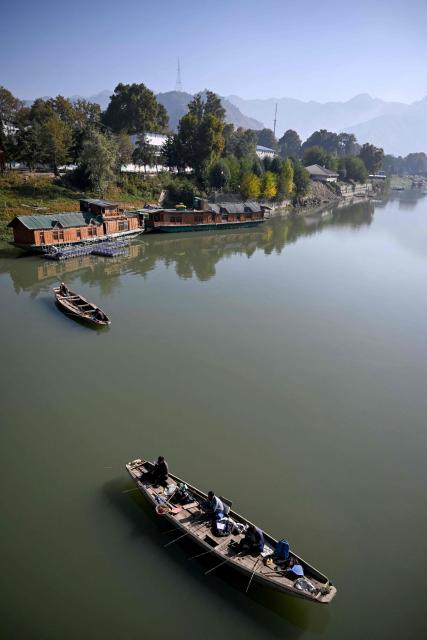 People fish in the Jhelum River in Srinagar on October 9, 2026. (Photo by Tauseef MUSTAFA / AFP)
