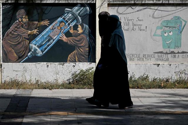 Women walk past an anti-drugs mural in Srinagar on October 9, 2026. (Photo by Tauseef MUSTAFA / AFP)