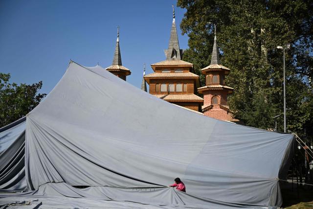 A worker sets up a tent for Friday prayers outside a mosque in Srinagar on October 9, 2026. (Photo by Tauseef MUSTAFA / AFP)