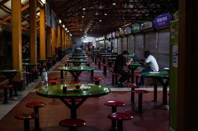 Diners eat at a food hawker centre in Singapore on October 8, 2026. (Photo by ANTHONY WALLACE / AFP)
