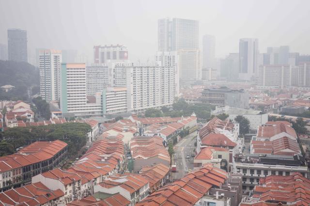 Buildings are seen shrouded by haze in Singapore on October 9, 2026. Indonesia has been battling fires for weeks in parts of Borneo and Sumatra, sending suffocating haze across the islands and neighbouring Malaysia and Singapore. (Photo by ANTHONY WALLACE / AFP)