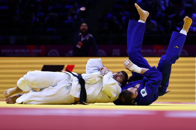 Italy's Gennaro Pirelli (white) competes against Spain's Nikoloz Sherazadishvili in the men's under 100 kg round of 16 at the World Judo Championships in Baku on October 9, 2026. (Photo by Anne-Christine POUJOULAT / AFP)