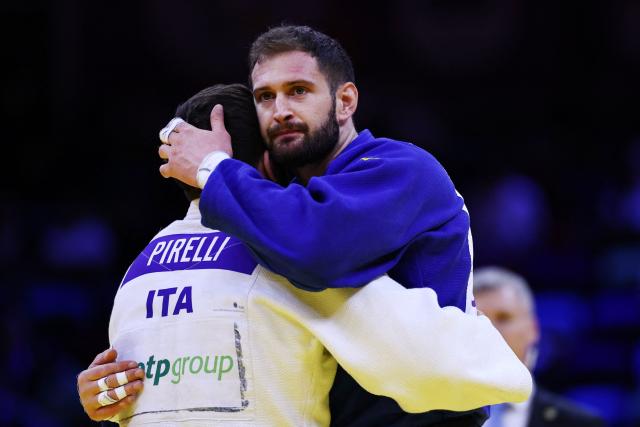 Italy's Gennaro Pirelli (white) and Spain's Nikoloz Sherazadishvili embrace each other after the men's under 100 kg round of 16 at the World Judo Championships in Baku on October 9, 2026. (Photo by Anne-Christine POUJOULAT / AFP)