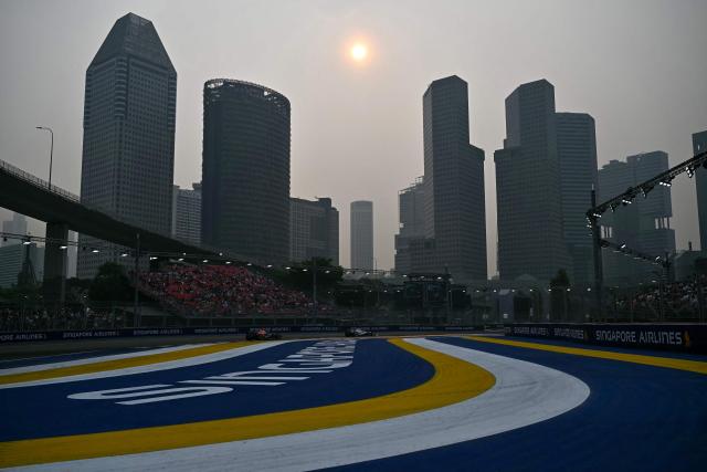 Red Bull Racing's French driver Isack Hadjar (L) and Cadillac's Finnish driver Valtteri Bottas (R) drive during a practice session ahead of the Formula One Singapore Grand Prix at the Marina Bay Street Circuit in Singapore on October 9, 2026. (Photo by Lillian SUWANRUMPHA / AFP)