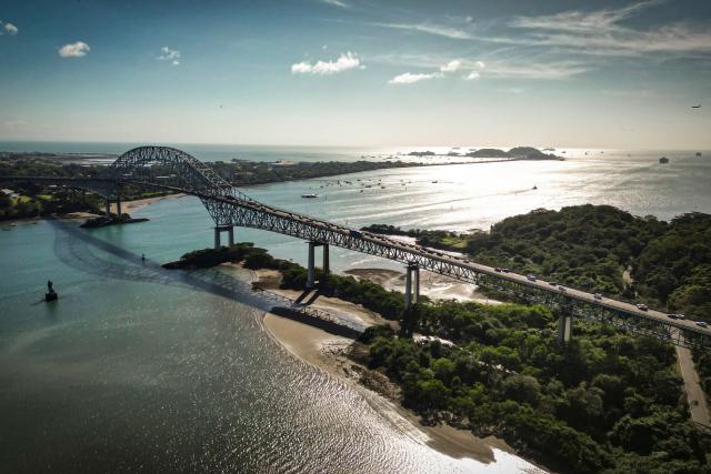 (FILES) This aerial view shows The Bridge of the Americas at the Pacific entrance of the Panama Canal, located next to the port of Balboa in Panama City on January 30, 2026. The EU removed Panama from its tax havens blacklist on October 9, 2026, after the country made progress on sharing tax information and reformed a "harmful" regime of exemptions for foreign-source income. (Photo by MARTIN BERNETTI / AFP)