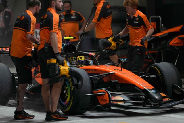 Team mechanics work on the car of McLaren's British driver Lando Norris in the pits during the sprint qualifying session ahead of the Formula One Singapore Grand Prix at the Marina Bay Street Circuit in Singapore on October 9, 2026. (Photo by Ng Han Guan / POOL / AFP)