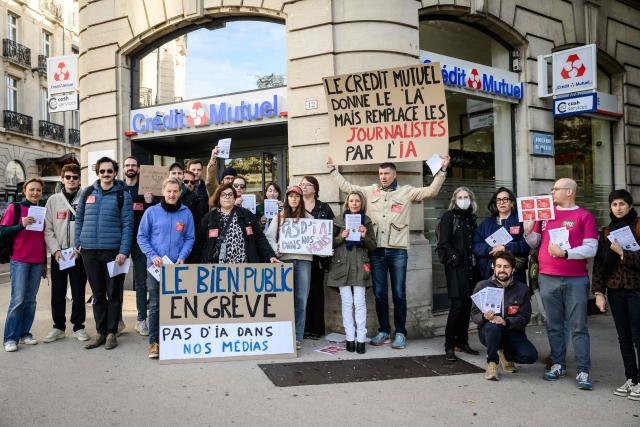 Journalists from the daily newspaper Le Bien Public, part of the Ebra group owned by Credit Mutuel bank, gather outside a Credit Mutuel bank branch to protest against the use of artificial intelligence in the group's publications in Dijon on October 9, 2026. (Photo by ARNAUD FINISTRE / AFP)