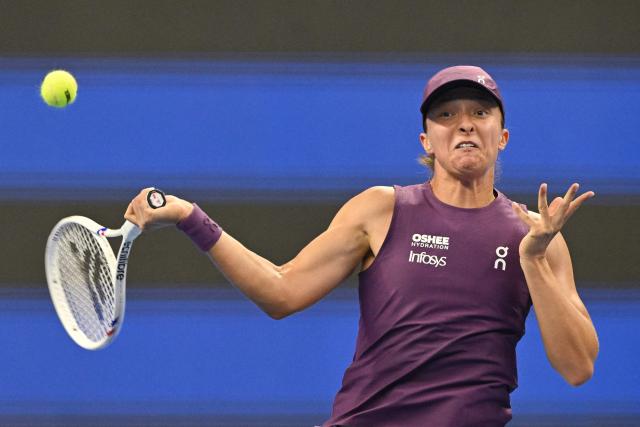 Poland's Iga Swiatek hits a return to Belgium's Elise Mertens during their women's singles quarter-final at the China Open tennis tournament in Beijing on October 9, 2026. (Photo by GREG BAKER / AFP)