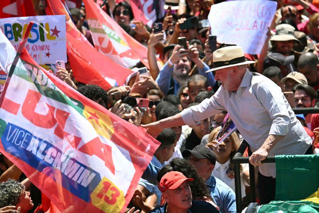 Brazil's President and presidential candidate Luiz Inacio Lula da Silva, of the Workers' Party (PT) greets supporters during a motorcade in Ceilandia, Federal District, Brazil on October 9, 2026. Lula da Silva, who has risen from the political ashes several times, is heading to a runoff election against right-wing senator Flavio Bolsonaro on October 25, after a shock second-place finish in the first-round vote. (Photo by Evaristo SA / AFP)