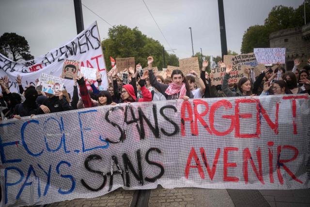 Students march behind a banner reading "School without money, country without a future" as thousands of students protest over learning conditions as part of a nationwide movement in Nantes on October 9, 2026. Since late September, pupils have barred the entrances to hundreds of schools, complaining of teacher absences, overloaded timetables, dilapidated classrooms and buildings ill-adapted to rising temperatures, among other grievances. (Photo by Loic VENANCE / AFP)