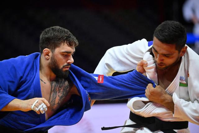 Italy's Gennaro Pirelli competes against Uzbekistan's Tulkinbek Turdiev (white) in the men's under 100 kg bronze medal bout at the World Judo Championships in Baku on October 9, 2026. (Photo by Alexander NEMENOV / AFP)