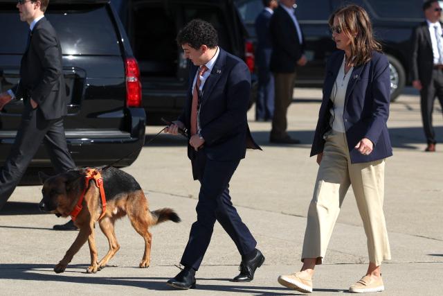A staff member walks Atlas, the Vance family dog as they arrive at Cincinnati/Northern Kentucky International Airport on October 9, 2026 in Hebron, Kentucky. Vance is campaigning for several Republican candidates on the November ballot. (Photo by Samuel Corum / POOL / AFP)
