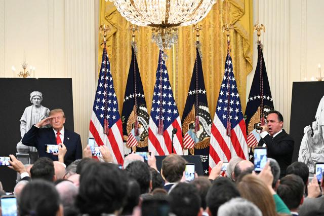 US President Donald Trump (L) salutes during the national anthem during a Columbus Day celebration in the East Room of the White House in Washington, DC, on October 9, 2026. (Photo by Alex WROBLEWSKI / AFP)