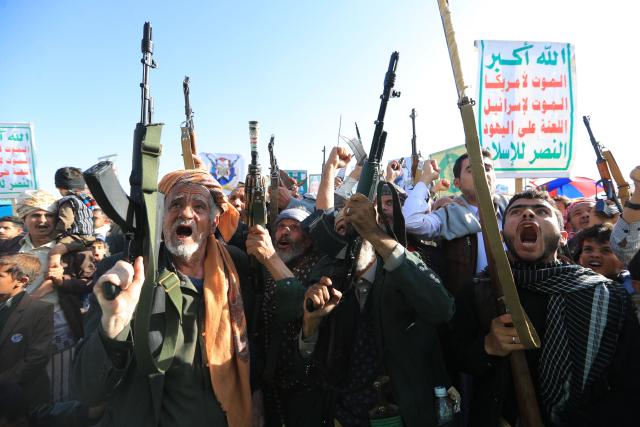 Supporters of the Houthi authorities brandish their weapons during a protest against Saudi intervention in Yemen, in Sanaa, on October 9, 2026. The Houthis, who are fighting the Saudi-backed, internationally recognised government, seized the coastline alongside crucial trade route during a lightning offensive last month, extending their control over all of Yemen's Red Sea coast. Yemeni government forces have been attempting for several days to retake coastal territory captured by the pro-Iranian fighters. (Photo by Mohammed HUWAIS / AFP)