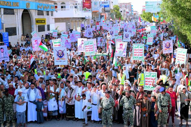 Supporters of the Houthi authorities hold placards and shout slogans as they protest against the Saudi intervention in Yemen, in the city of Hodeida on October 9, 2026. The Houthis, who are fighting the Saudi-backed, internationally recognised government, seized the coastline alongside crucial trade route during a lightning offensive last month, extending their control over all of Yemen's Red Sea coast. Yemeni government forces have been attempting for several days to retake coastal territory captured by the pro-Iranian fighters. (Photo by Zayed Al-Waqidi / AFP) / 