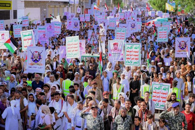 Supporters of the Houthi authorities hold placards as they protest against the Saudi intervention in Yemen, in the city of Hodeida on October 9, 2026. The Houthis, who are fighting the Saudi-backed, internationally recognised government, seized the coastline alongside crucial trade route during a lightning offensive last month, extending their control over all of Yemen's Red Sea coast. Yemeni government forces have been attempting for several days to retake coastal territory captured by the pro-Iranian fighters. (Photo by Zayed Al-Waqidi / AFP) / 
