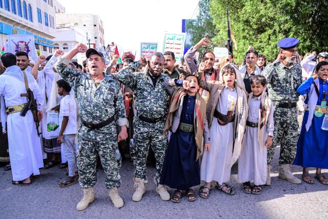 Supporters of the Houthi authorities hold placards and shout slogans as they protest against the Saudi intervention in Yemen, in the city of Hodeida on October 9, 2026. The Houthis, who are fighting the Saudi-backed, internationally recognised government, seized the coastline alongside crucial trade route during a lightning offensive last month, extending their control over all of Yemen's Red Sea coast. Yemeni government forces have been attempting for several days to retake coastal territory captured by the pro-Iranian fighters. (Photo by Zayed Al-Waqidi / AFP) / 