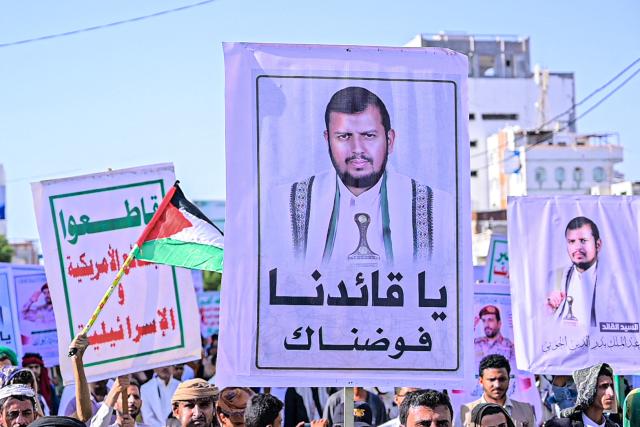 Supporters of the Houthi authorities hold a placard depicting the group's leader Abdul Malik al-Houthi, as they protest against the Saudi intervention in Yemen, in Hodeida on October 9, 2026. The Houthis, who are fighting the Saudi-backed, internationally recognised government, seized the coastline alongside crucial trade route during a lightning offensive last month, extending their control over all of Yemen's Red Sea coast. Yemeni government forces have been attempting for several days to retake coastal territory captured by the pro-Iranian fighters. (Photo by Zayed Al-Waqidi / AFP) / 