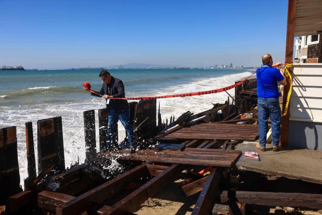 People tape off the damaged boardwalk due to the storm surge in Long Beach, California, on October 9, 2026. The National Weather Service office in San Diego on October 9 issued a rare tropical storm watch for most of San Diego County, in Southern California, meaning that tropical storm-force winds are possible somewhere in the area over the next 48 hours. It’s only the second time a tropical storm watch has ever been issued in California. (Photo by David Swanson / AFP)