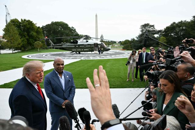 US President Donald Trump speaks to the press alongside former boxer Mike Tyson before boarding Marine One as he departs from the South Lawn of the White House in Washington, DC, on October 9, 2026. President Trump is traveling to Syracuse, New York, to speak at a campaign rally. (Photo by Alex WROBLEWSKI / AFP)