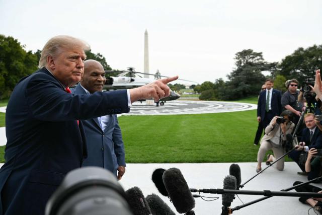 US President Donald Trump speaks to the press alongside former boxer Mike Tyson before boarding Marine One as he departs from the South Lawn of the White House in Washington, DC, on October 9, 2026. Trump is traveling to Syracuse, New York, to speak at a campaign rally. (Photo by Alex WROBLEWSKI / AFP)